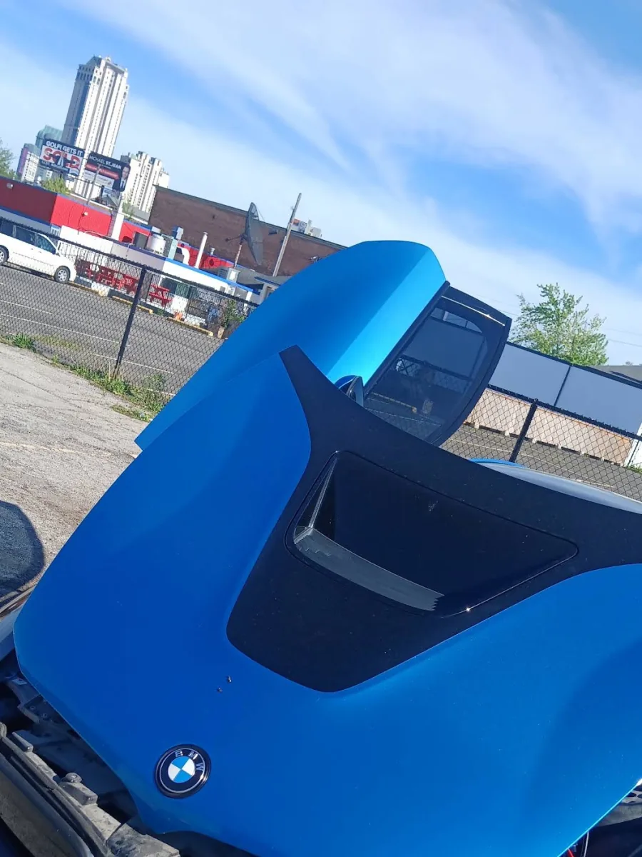 Voiture bleue avec le capot ouvert lors d’une visite mobile de Babbal